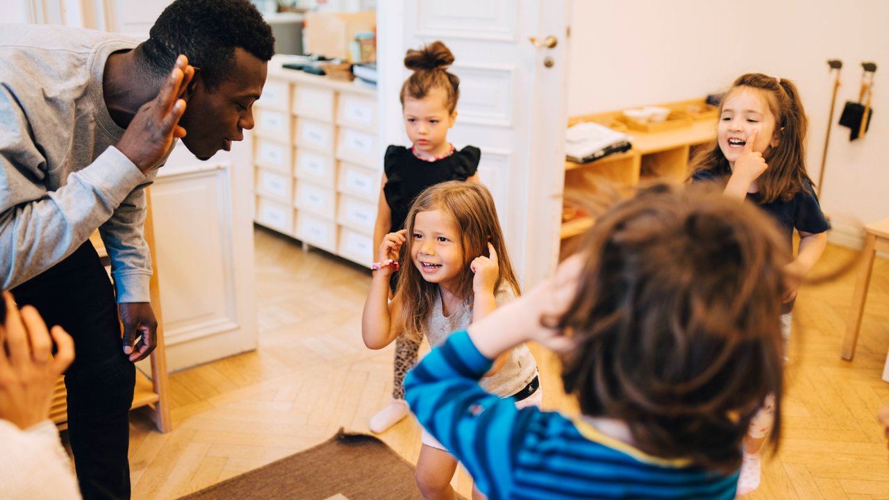 Kita-Konzepte: Erzieher spricht mit Kindern in Kindergarten