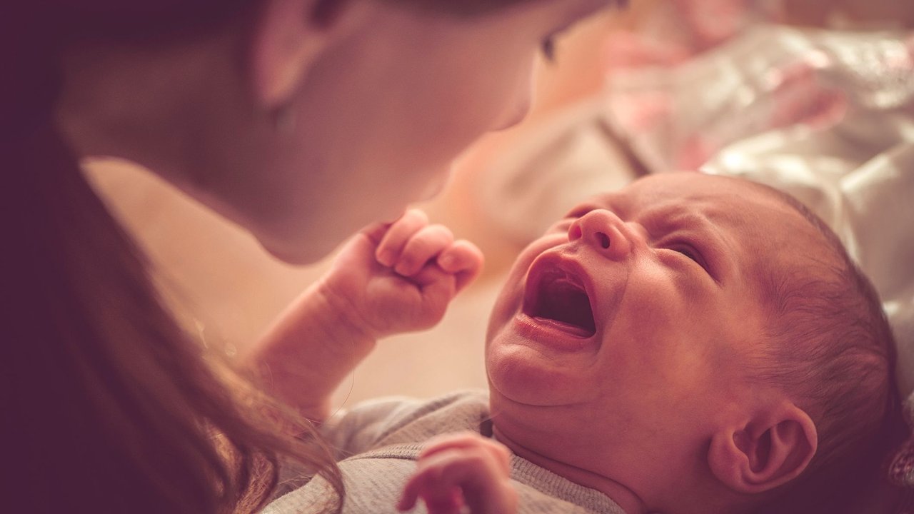 Mother with her newborn baby girl crying