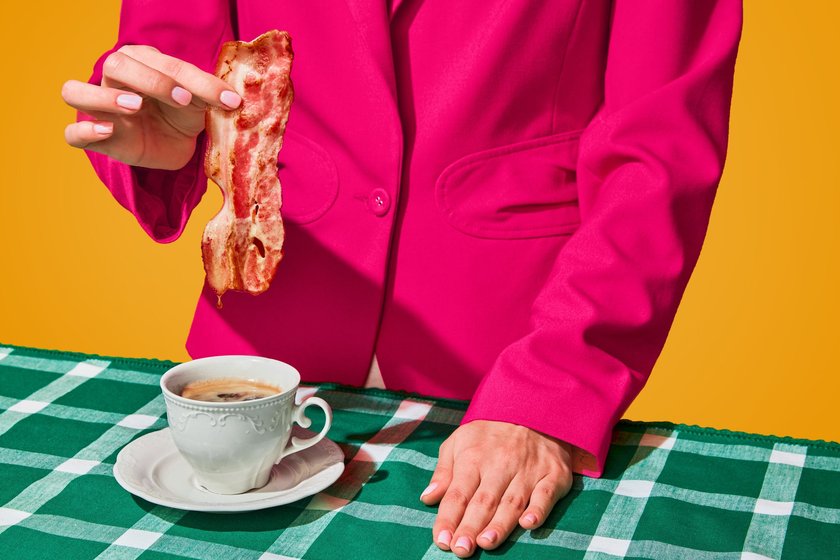 Frau tunkt ein Stück Speck in ihren Kaffee