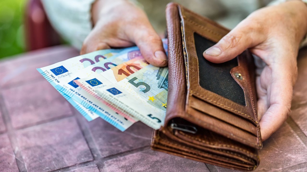 Hinzuverdienst Rente: Frau hält Geld in den Händen