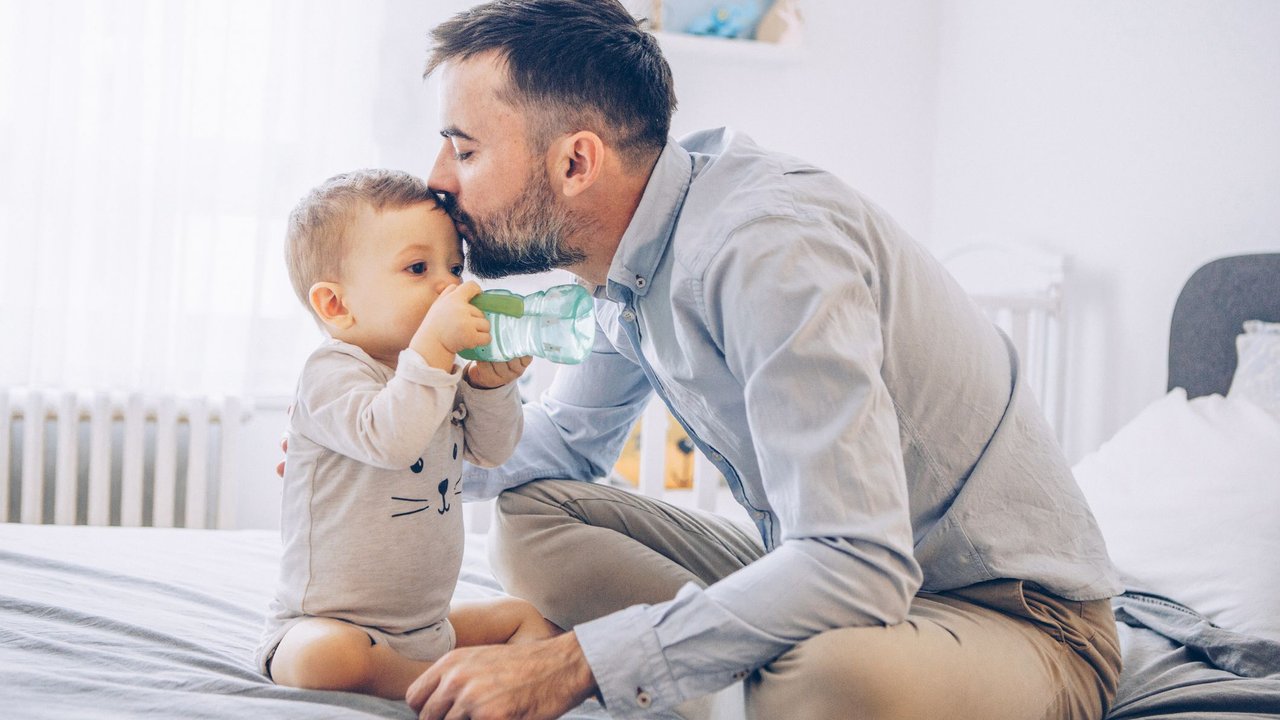 Babywasser: Papa gibt Baby Wasser zu trinken